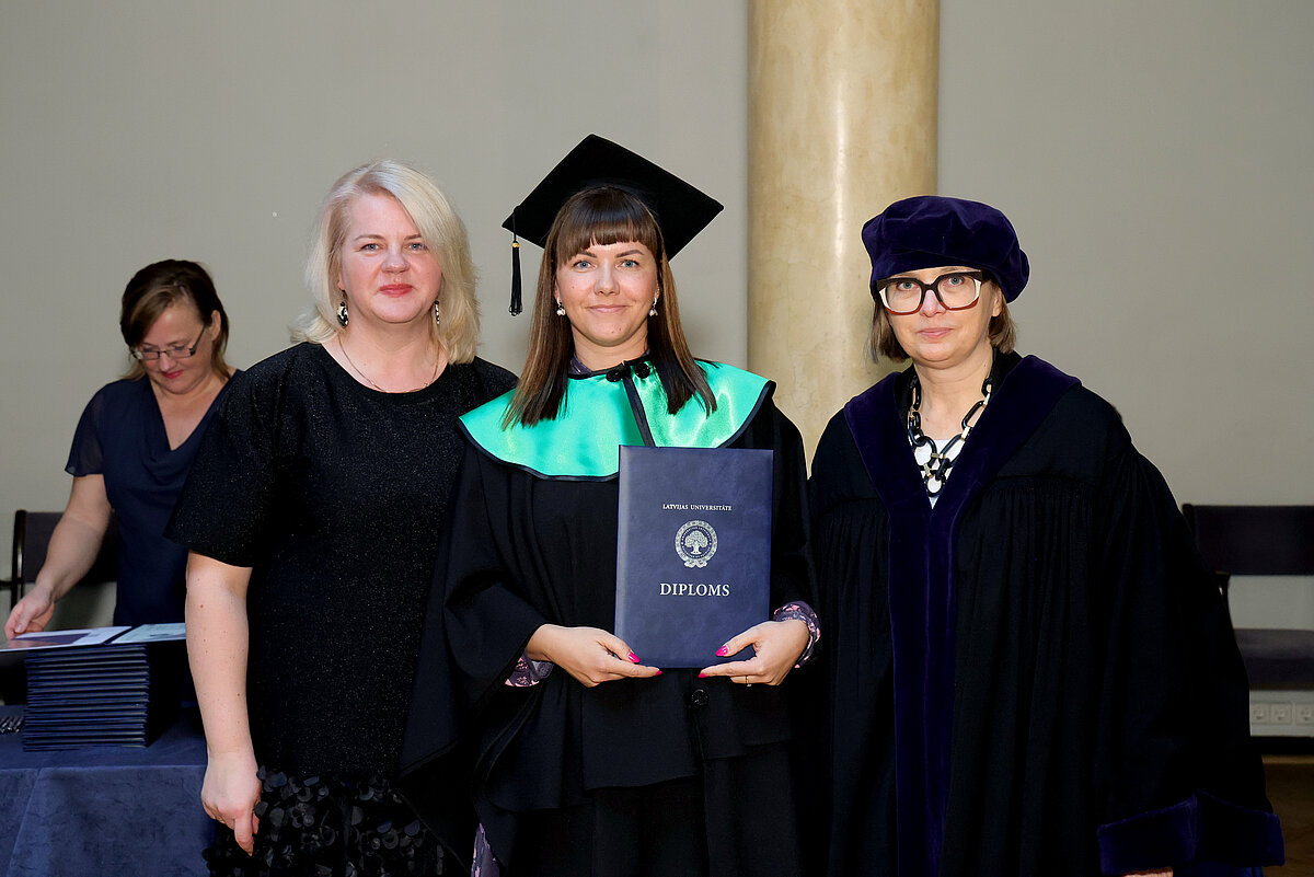 LU Madonas filiāles absolvente Mudīte Brīdaka, programmas direktore Antra Randoha un IZPF dekāne prof. Linda Daniela izlaidumā 25.02.2025.